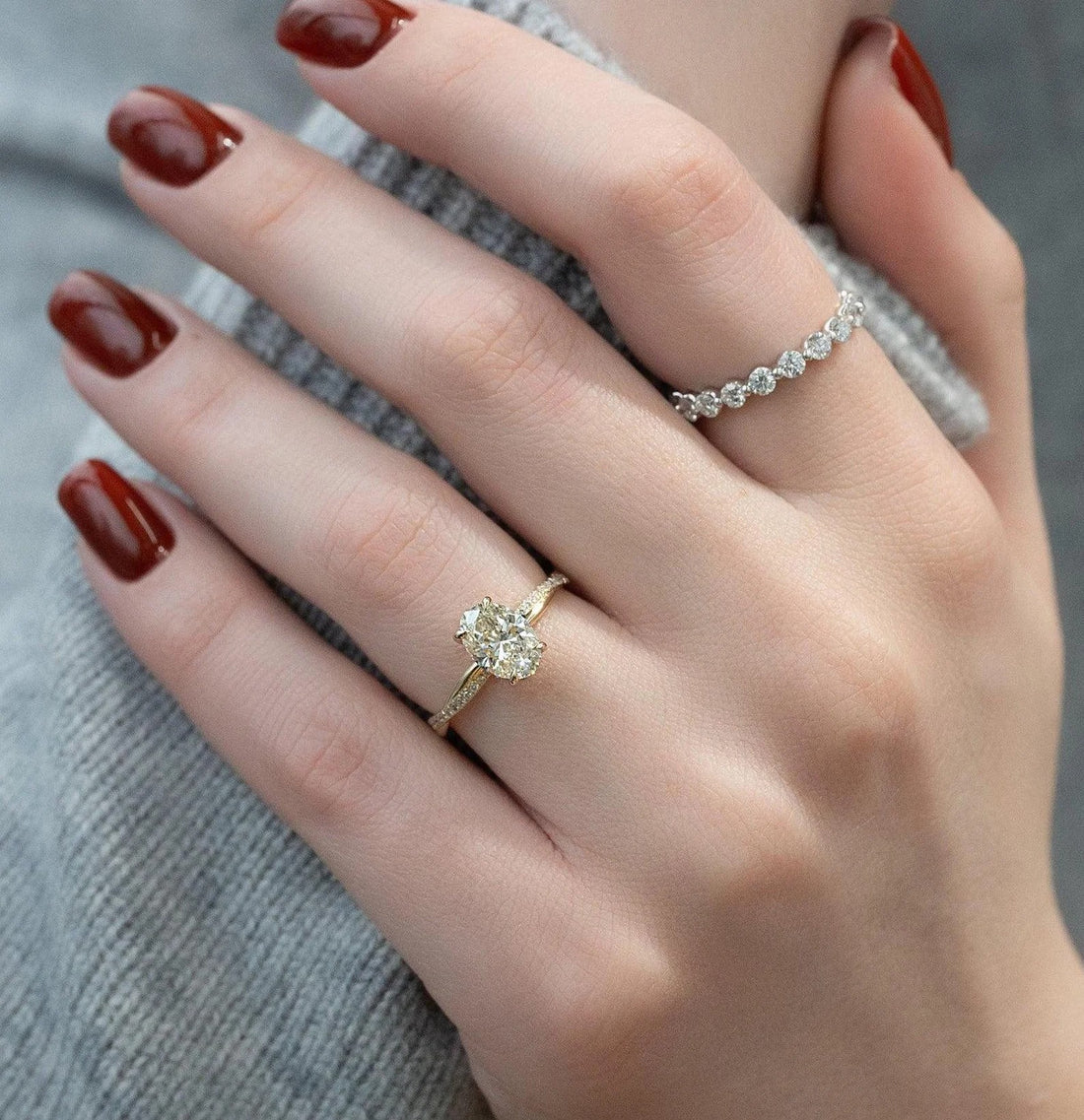 Oval cut lab grown diamond engagement ring with pave band in yellow gold shown on the hand