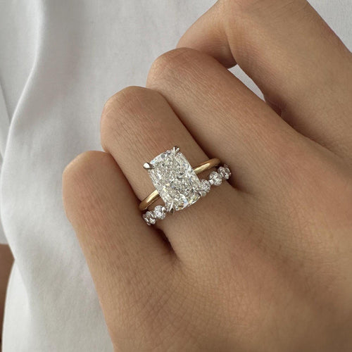 Elongated cushion lab grown diamond hidden halo bridal set worn on the hand with a floating stone band