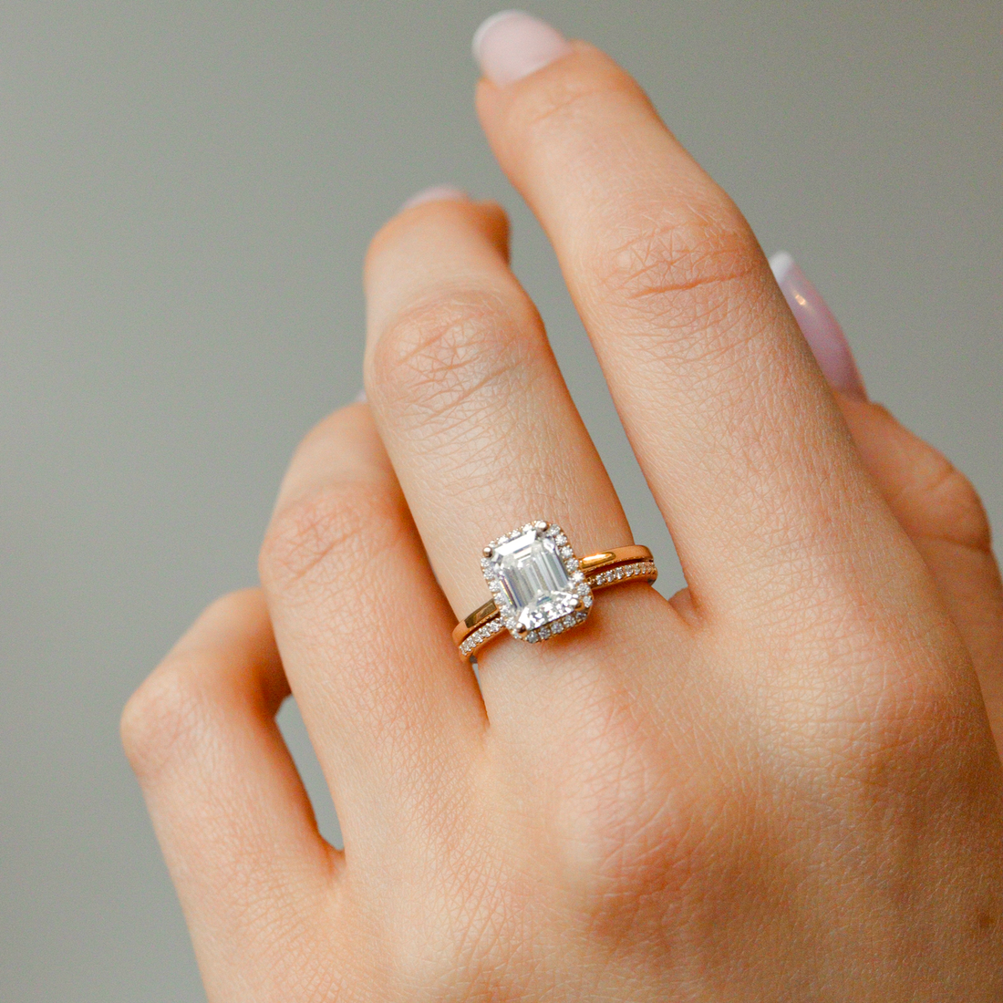 Emerald cut lab grown diamond halo engagement ring on a plain band
