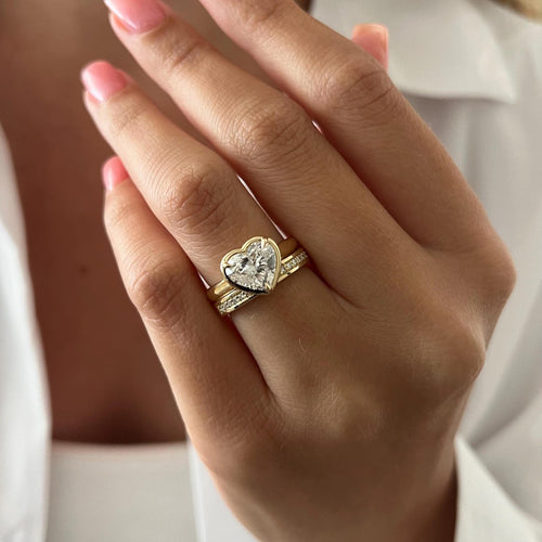 Heart moissanite bezel bridal set in yellow gold worn on the hand