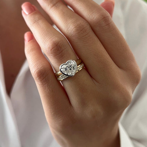 Heart moissanite bezel bridal set with straight pave band worn on the hand