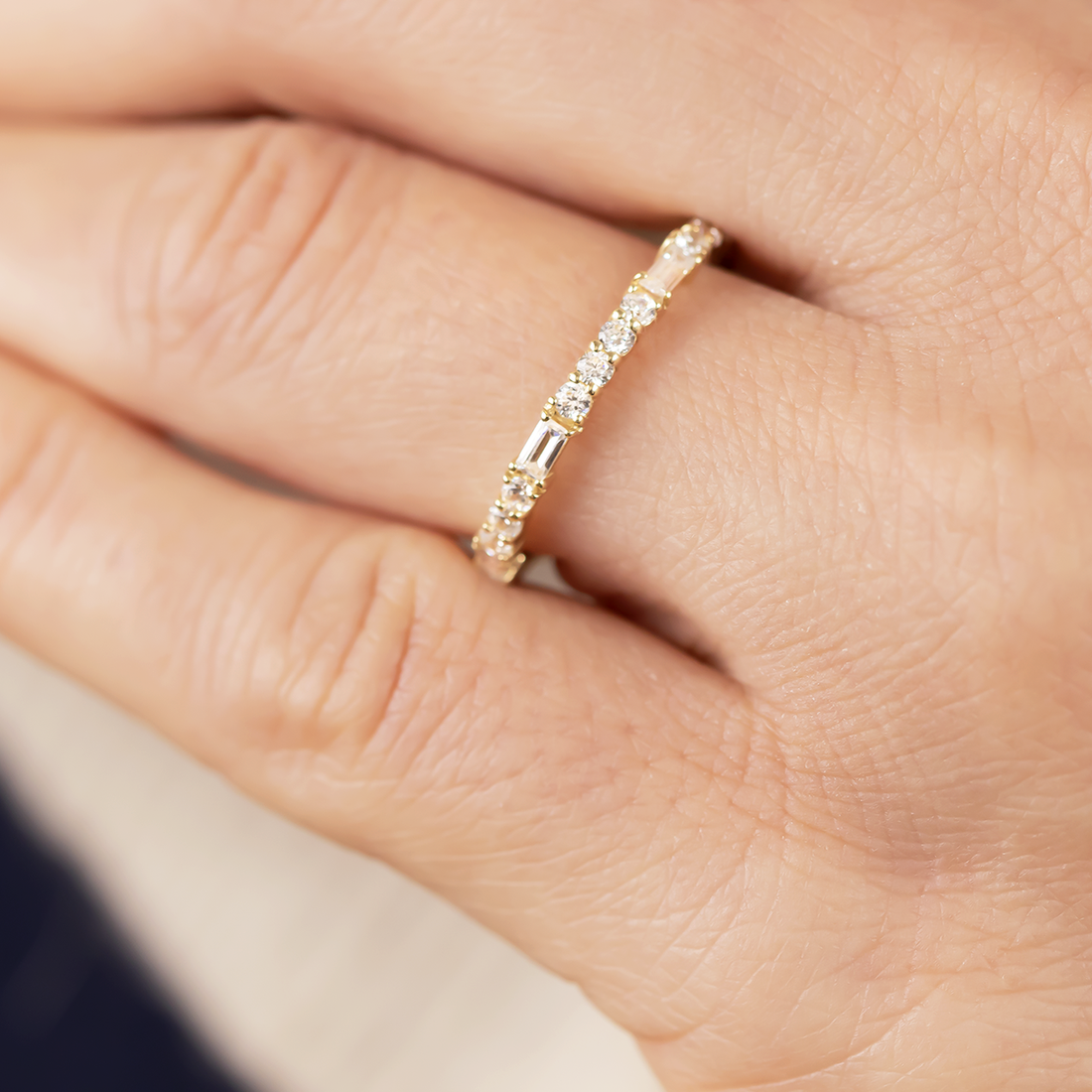 Full eternity wedding band with round and baguette moissanite worn on the ring finger