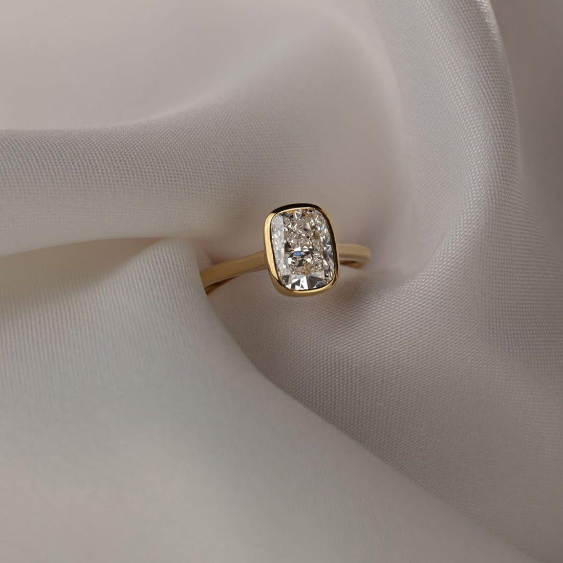 Elongated cushion cut moissanite bezel set engagement ring in 14K gold