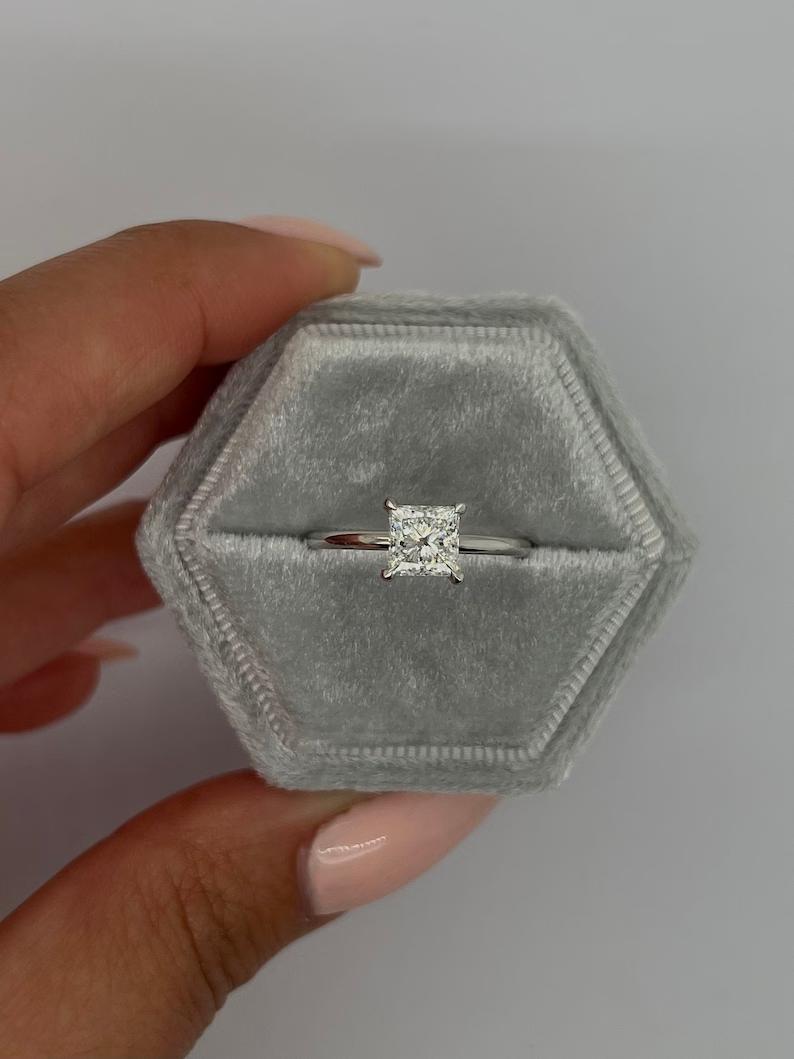 Princess cut lab grown diamond solitaire ring in white metal shown in a ring box