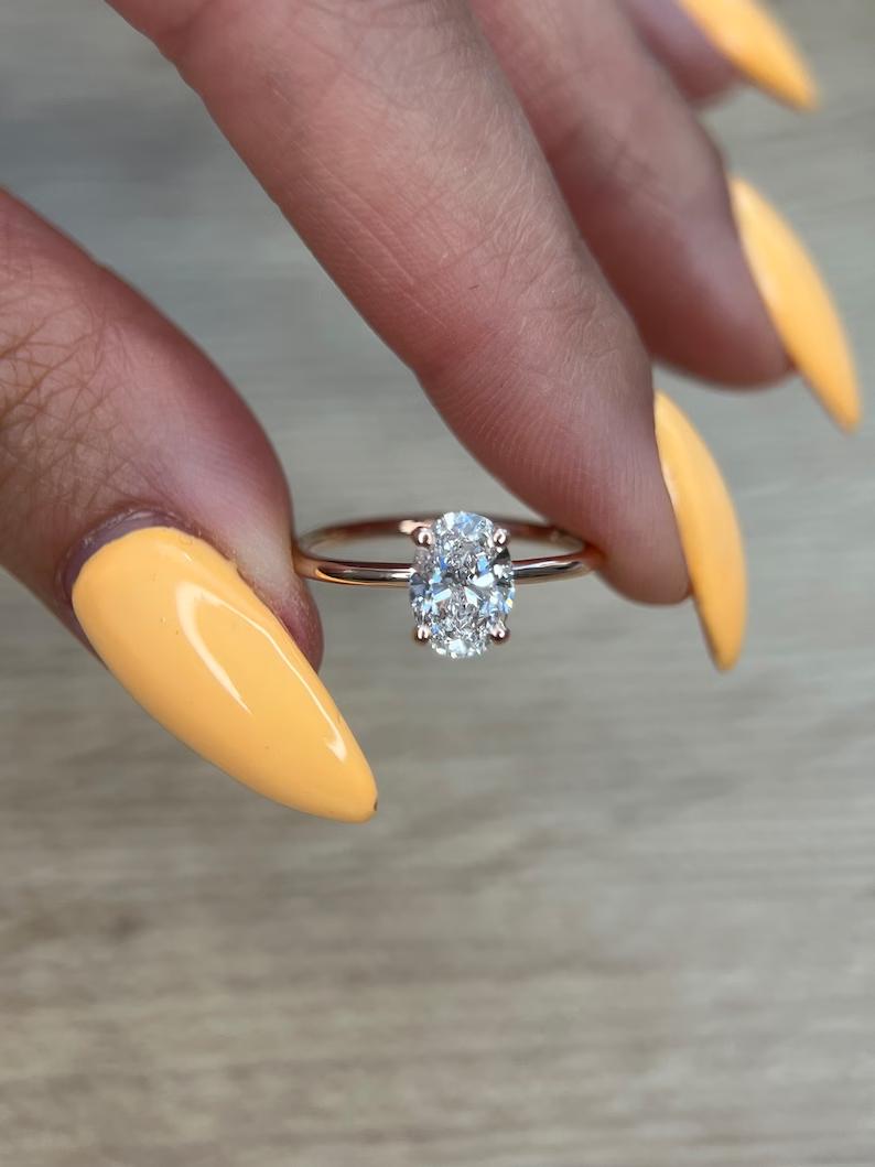 Oval cut lab grown diamond solitaire ring in rose gold on a thin plain band
