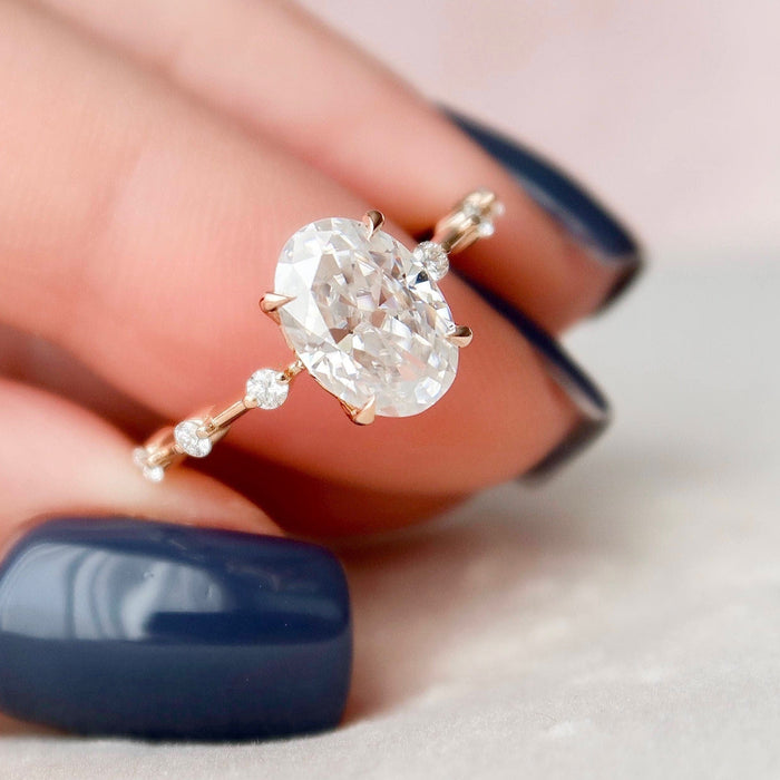 Oval cut moissanite four prong solitaire engagement ring in rose gold held in hand