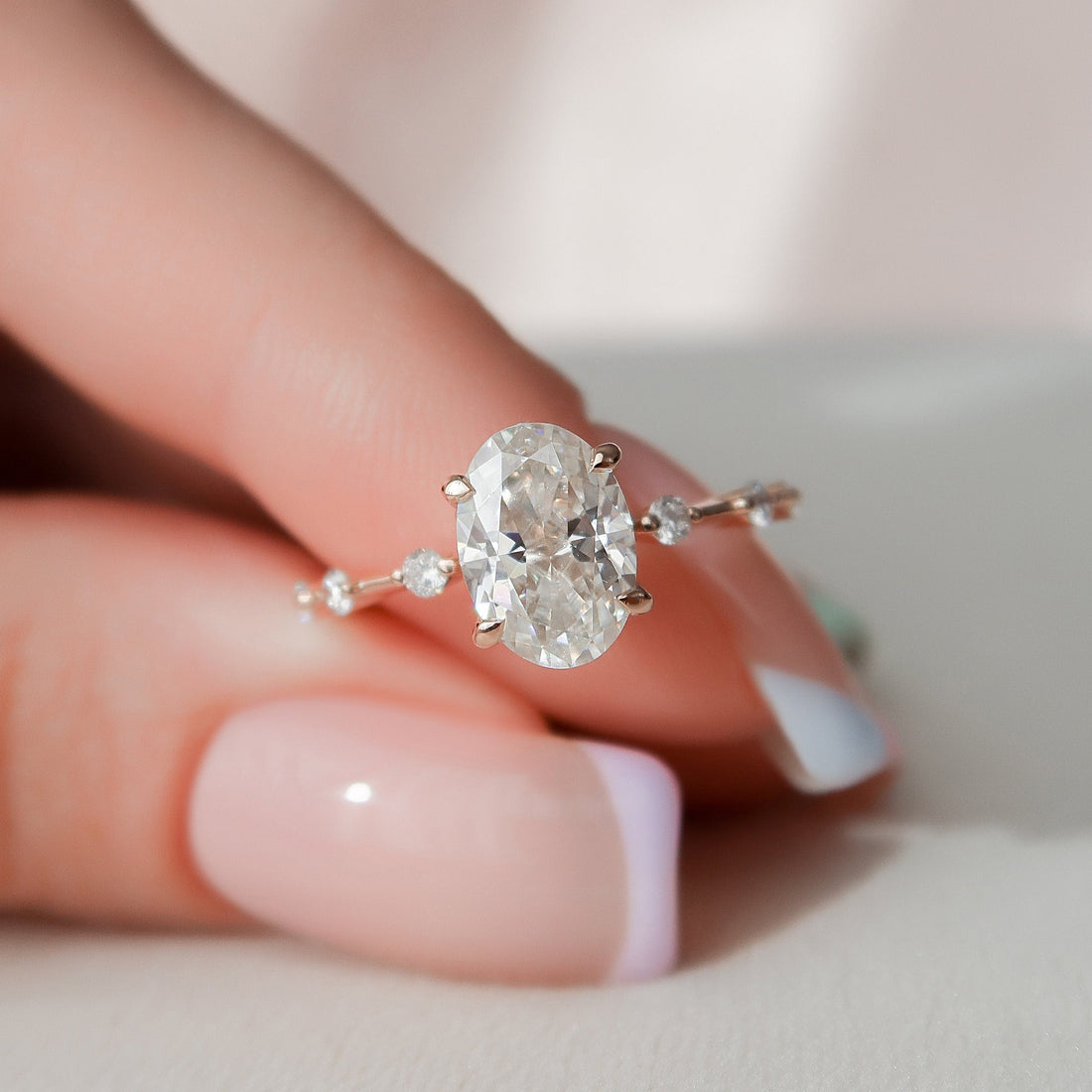 Oval cut moissanite solitaire engagement ring in rose gold held in hand