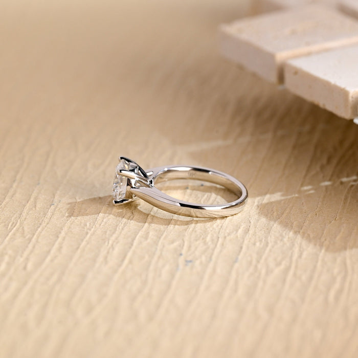 Round moissanite cathedral solitaire engagement ring held by four claws on a polished white gold band that sweeps up to the stone, view 2