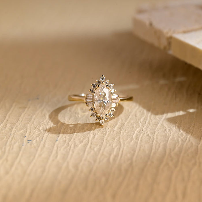 Art deco marquise cut moissanite halo engagement ring with baguette side clusters on a yellow gold band
