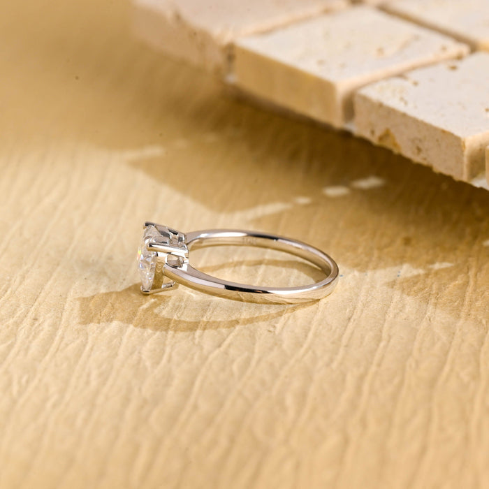 Heart shape moissanite solitaire engagement ring held in three slim claws on a thin polished white gold band, view 2