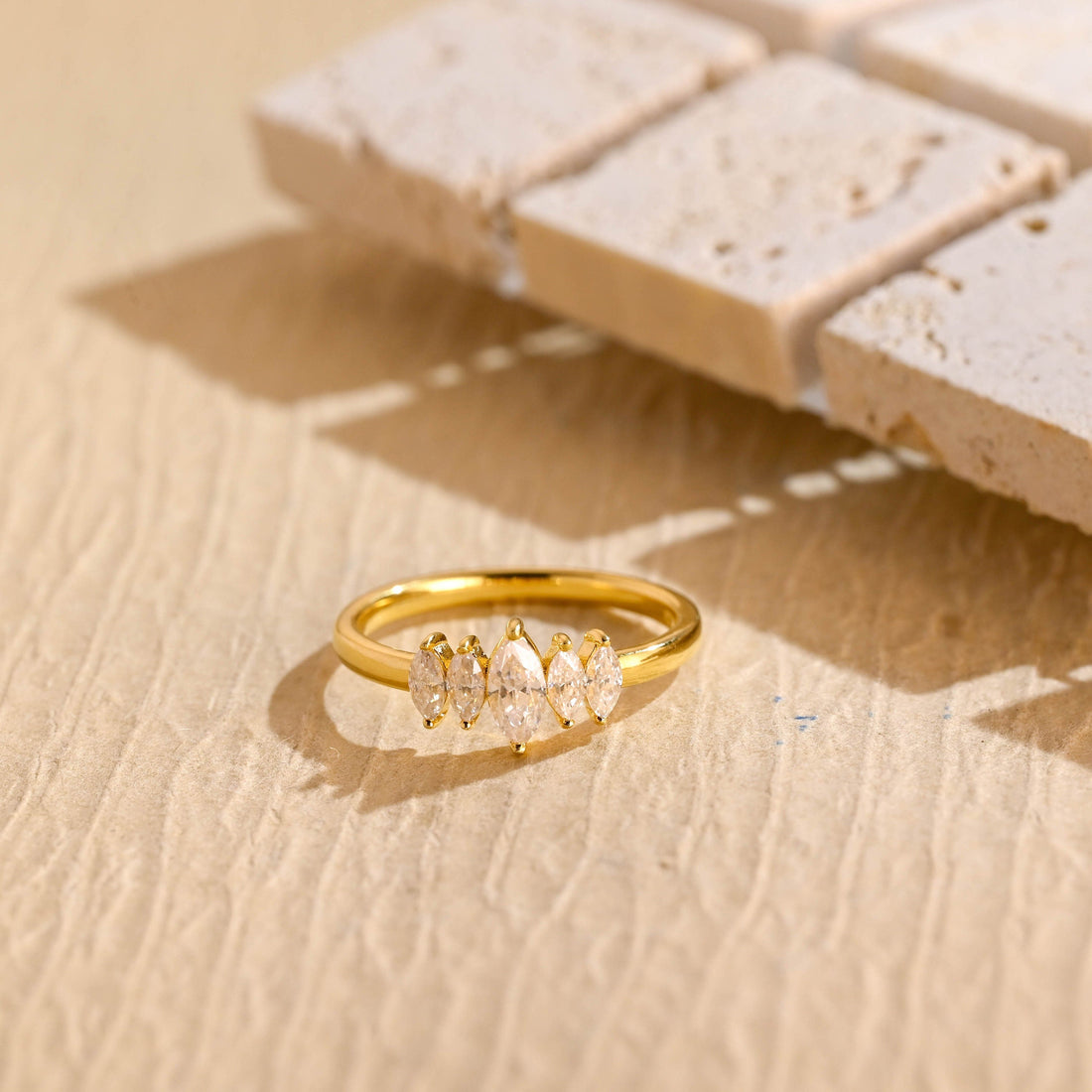 Five stone marquise cut moissanite ring with graduated stones on a slim yellow gold band
