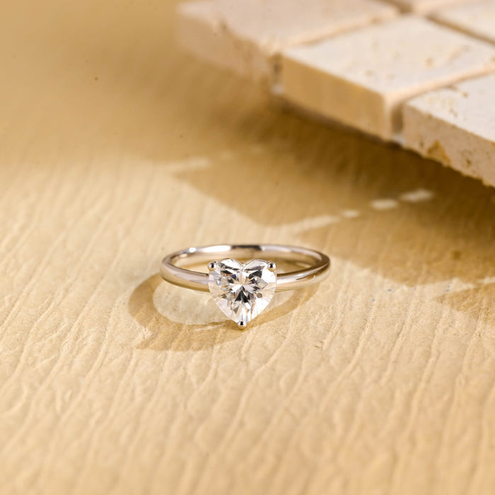 Classic heart cut moissanite solitaire engagement ring in a three claw setting on a slim plain white gold band