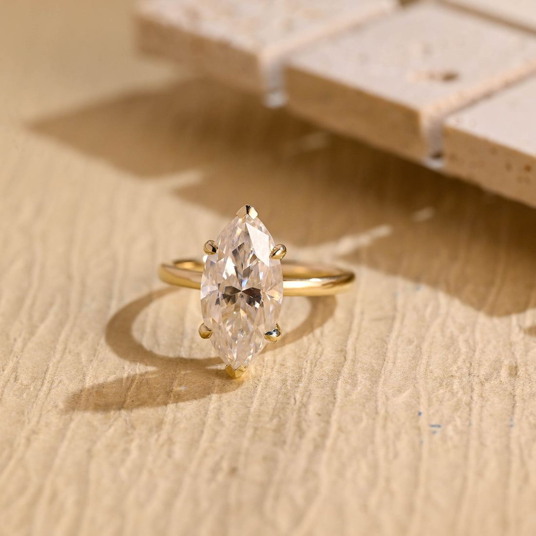 Large marquise cut moissanite six claw solitaire engagement ring on a plain polished yellow gold band