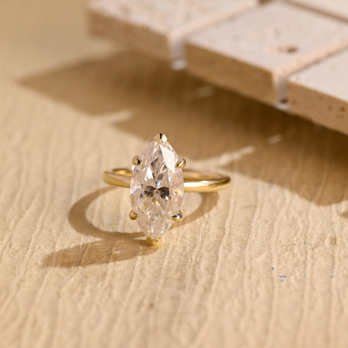 Large marquise cut moissanite six claw solitaire engagement ring on a plain polished yellow gold band