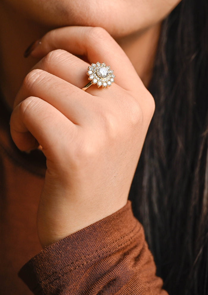 Round moissanite double halo sunburst engagement ring with a pave inner halo and an outer ring of larger round stones like petals on a slim yellow gold band, view 2
