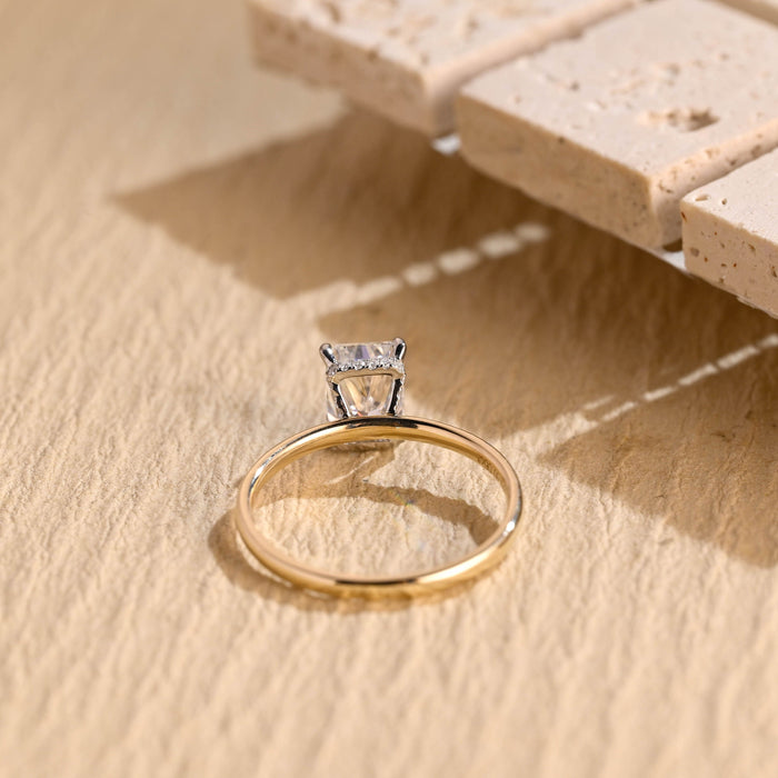 Radiant cut moissanite hidden halo engagement ring with white claws on a thin polished yellow gold band, view 2