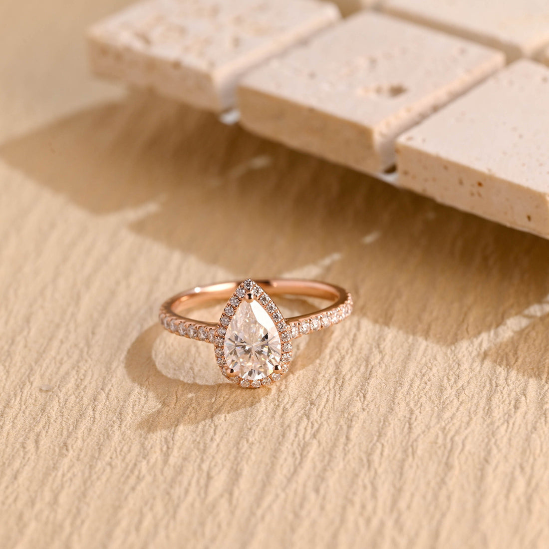 Pear cut moissanite classic halo engagement ring with a teardrop halo and a pave set rose gold band