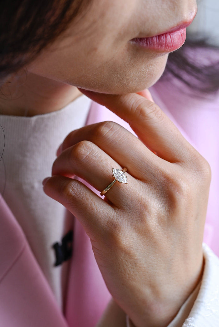 Marquise cut moissanite cathedral six claw solitaire engagement ring on a tapered polished yellow gold band, view 2