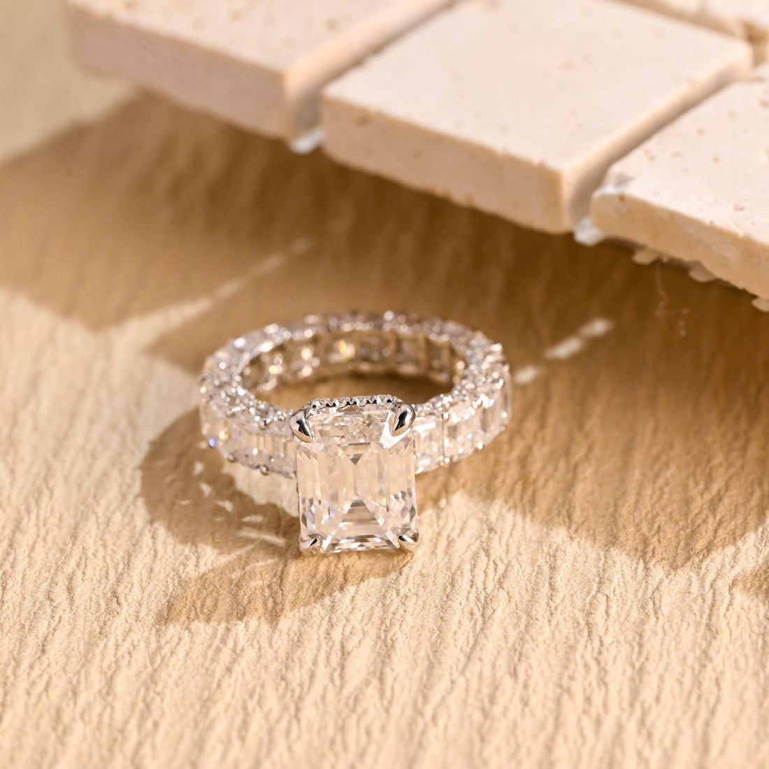 Emerald cut moissanite hidden halo engagement ring with a wide band set all round with emerald cut stones in white gold