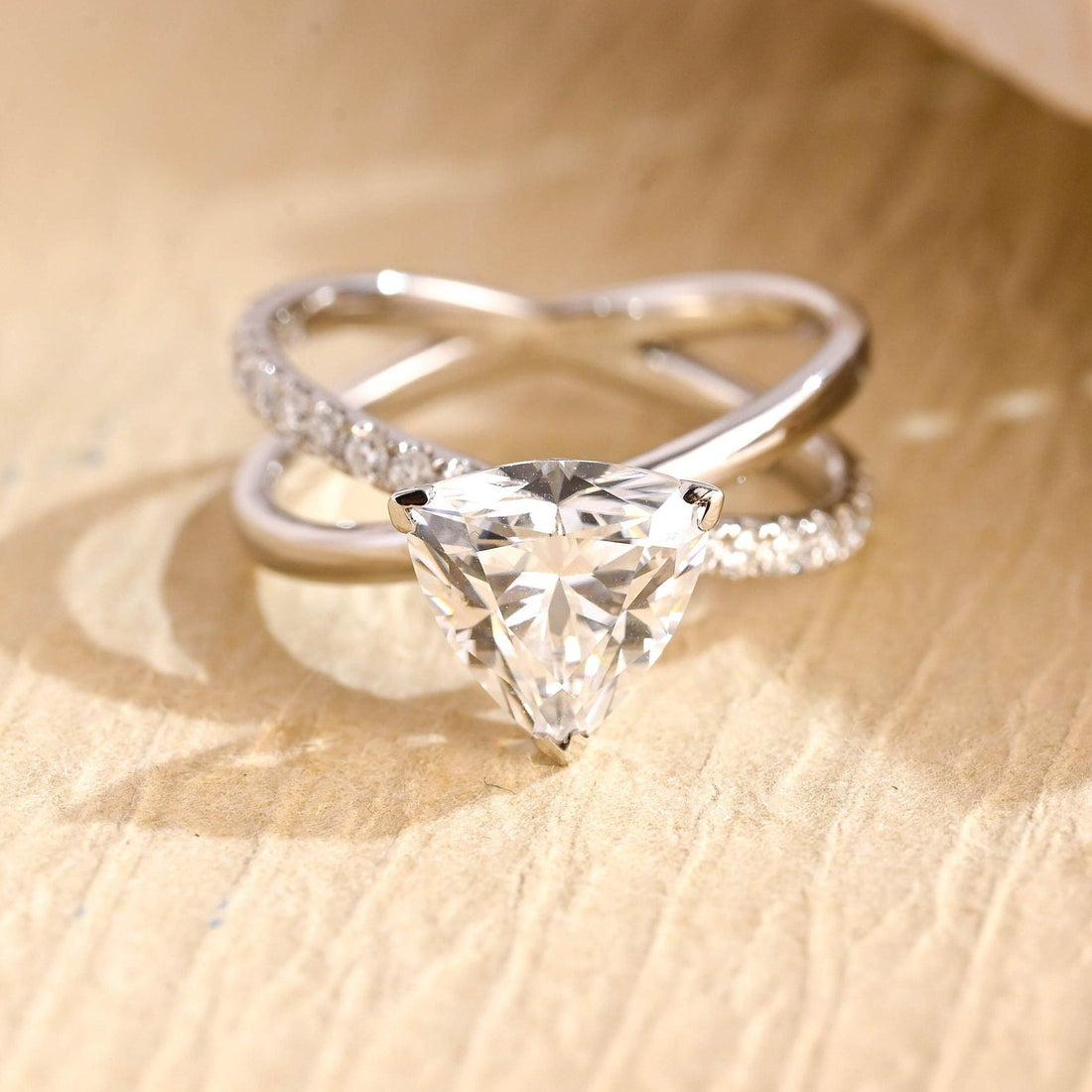 Trillion cut moissanite crossover engagement ring with a pave set arm on a white gold band