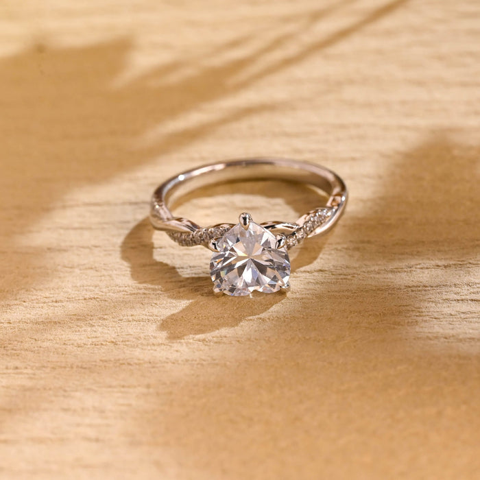 Heart cut moissanite solitaire engagement ring on a twisted pave set white gold band