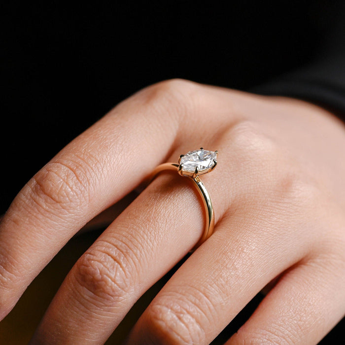Marquise cut moissanite six claw solitaire engagement ring on a smooth polished white gold band that flares up to the stone, view 2