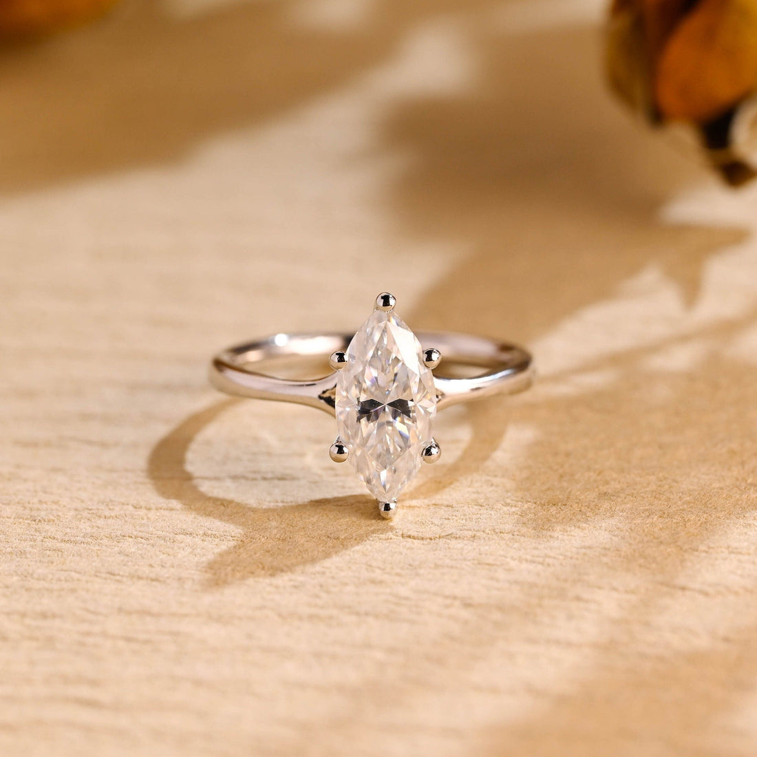 Marquise cut moissanite six claw solitaire engagement ring on a smooth polished white gold band that flares up to the stone
