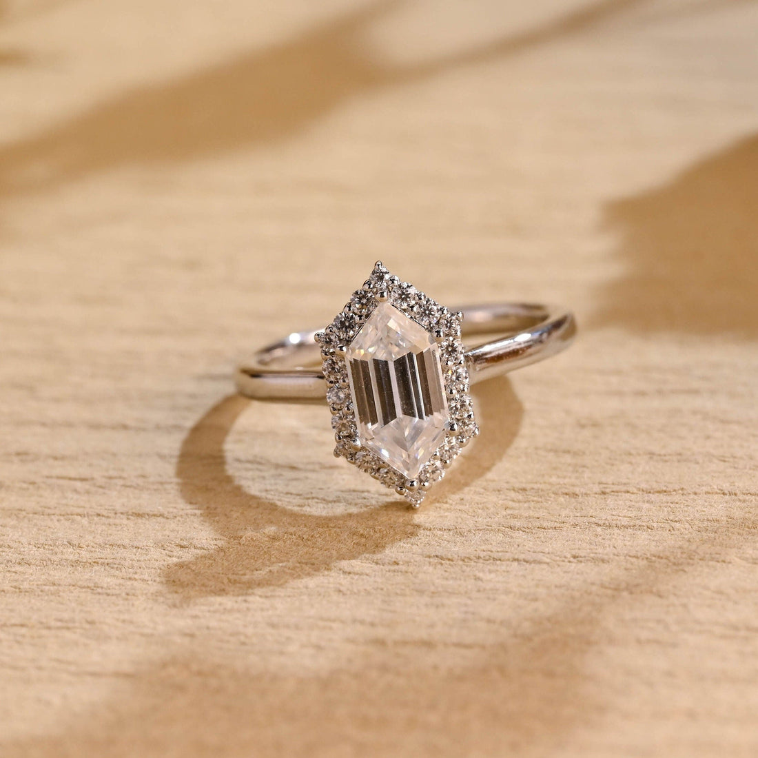 Elongated hexagon cut moissanite halo engagement ring on a slim polished white gold band