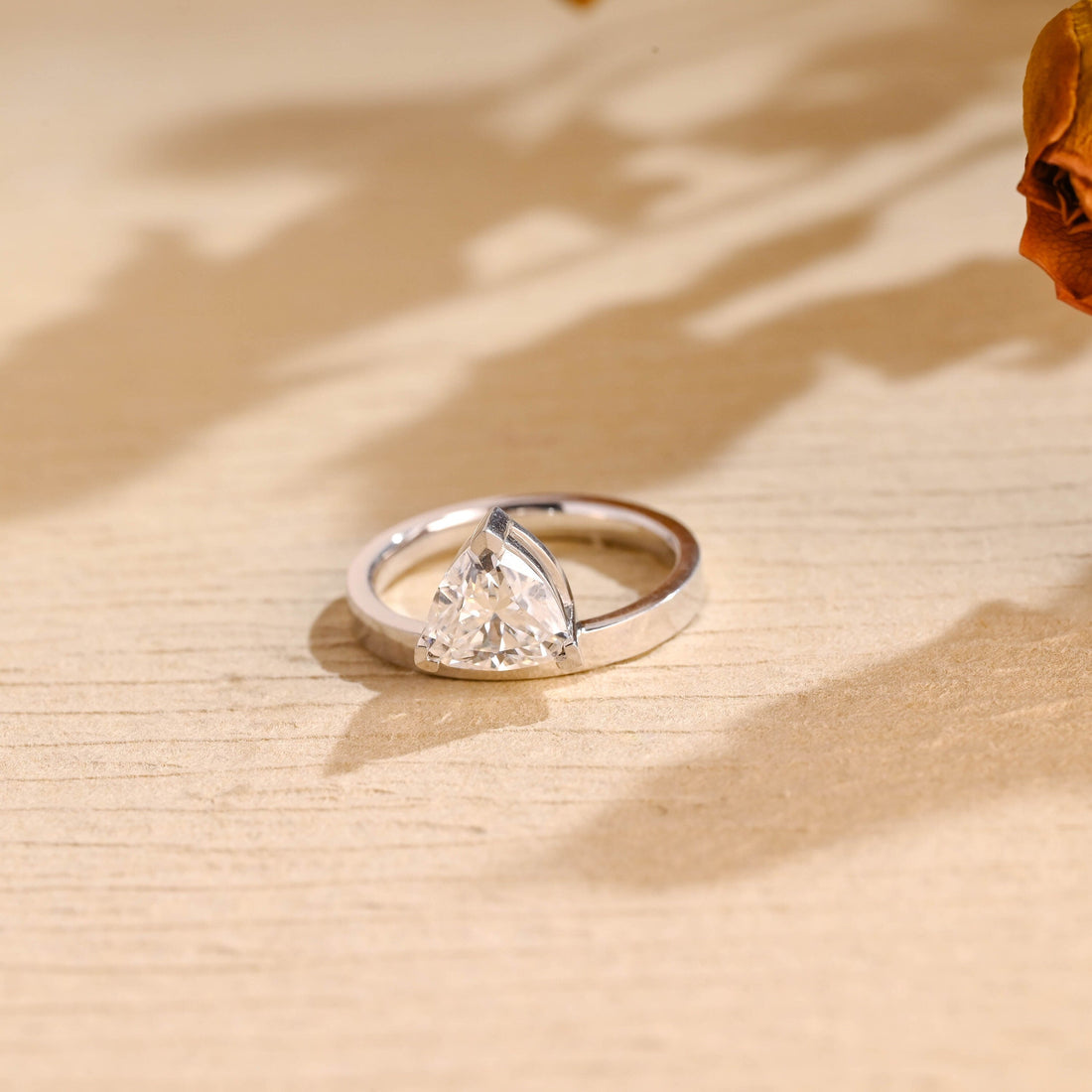 Trillion cut moissanite solitaire engagement ring on a thick flat polished white gold band