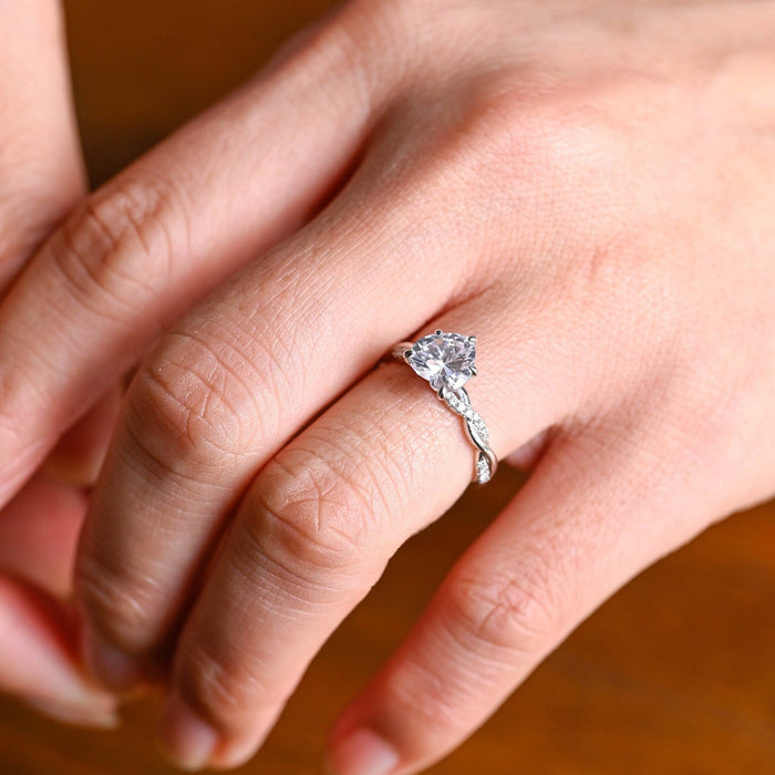 Heart cut moissanite solitaire engagement ring on a twisted pave set white gold band, view 2