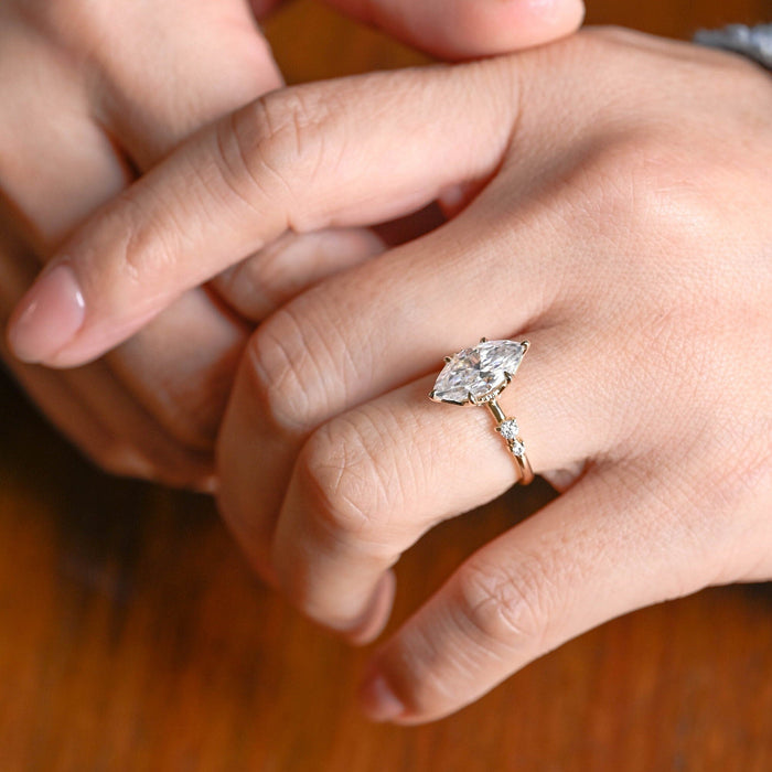 Marquise cut moissanite six claw engagement ring on an organic twig style yellow gold band with claw set round stones on the shoulders, view 2