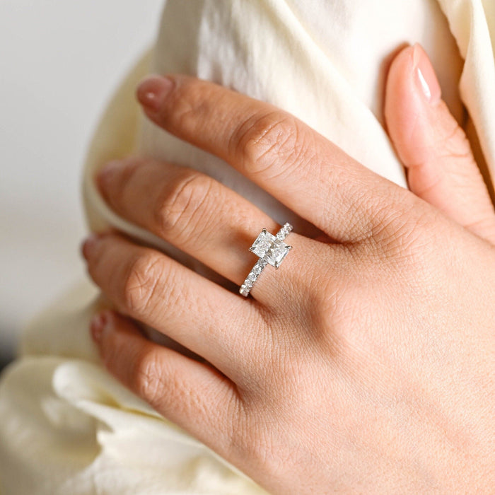 Radiant cut moissanite hidden halo engagement ring in four claws with a graduated pave set white gold band, view 2