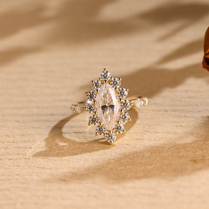 Marquise cut moissanite starburst floral halo engagement ring with spaced round and marquise shoulder stones on a yellow gold band