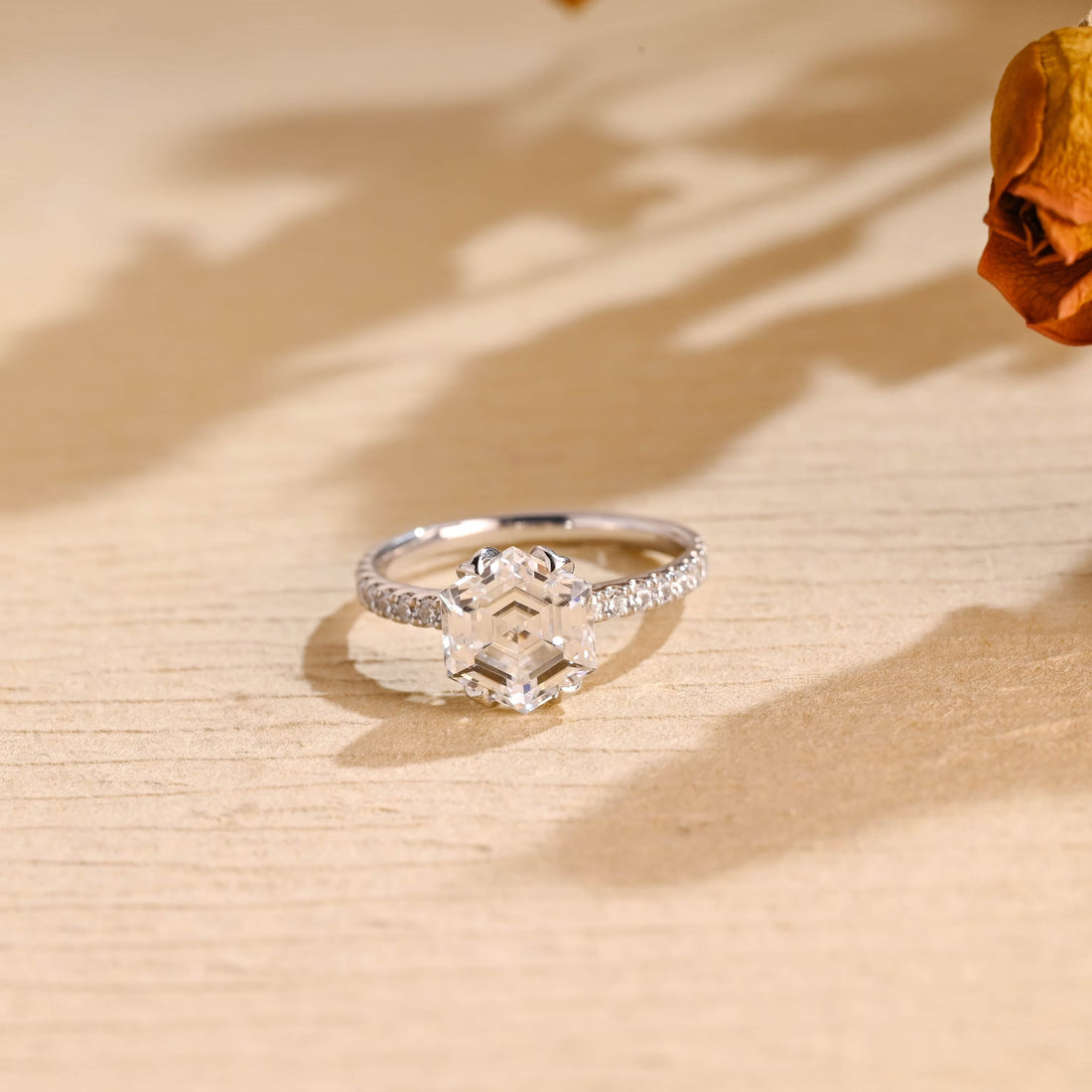 Hexagon cut moissanite double claw solitaire engagement ring on a pave set white gold band