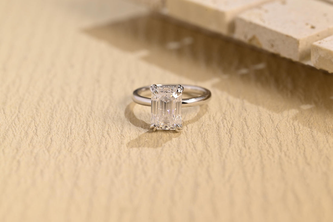 Emerald cut moissanite hidden halo engagement ring with double claws on a plain slim white gold band