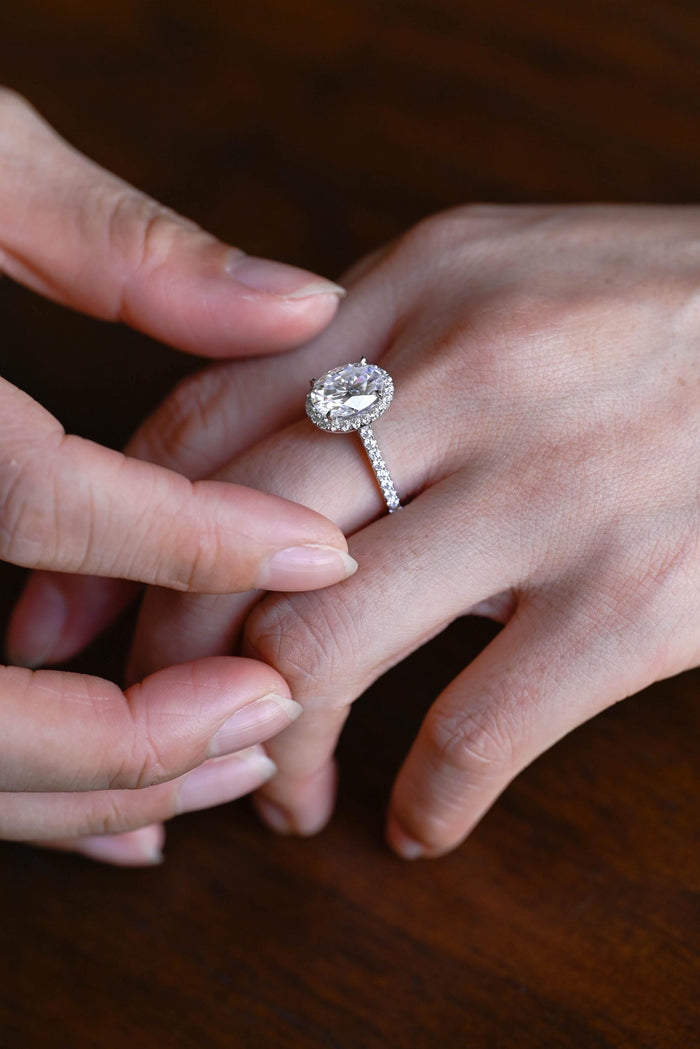 Oval moissanite classic halo engagement ring with a single pave halo and a slim pave set white gold band, view 2