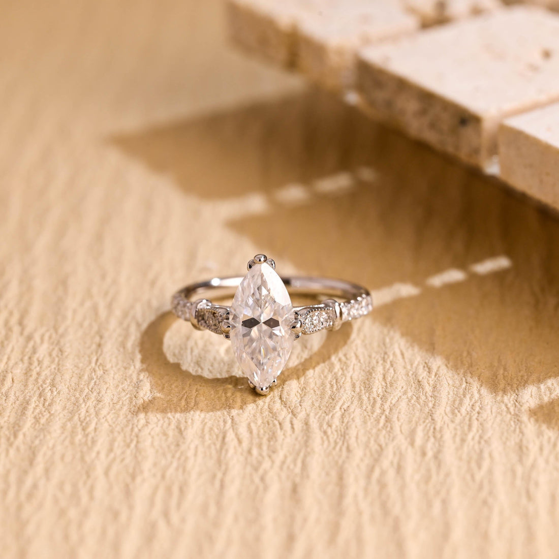 Vintage marquise cut moissanite engagement ring with double claws and milgrain pave shoulders on a white gold band