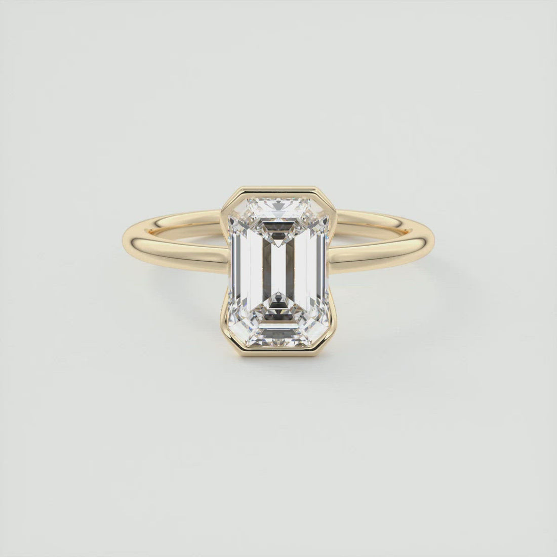 Emerald cut moissanite flush half bezel engagement ring in yellow gold