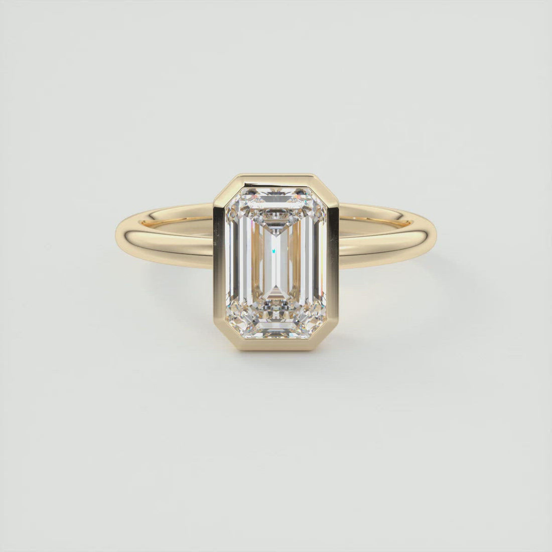 Emerald cut moissanite full bezel solitaire engagement ring in yellow gold