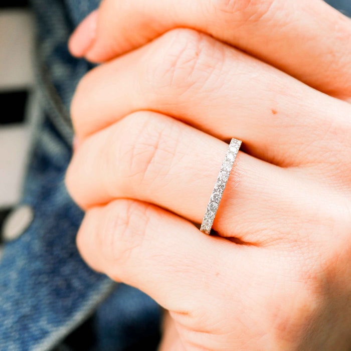 White gold scallop pave moissanite band worn on a hand, side view of the stones