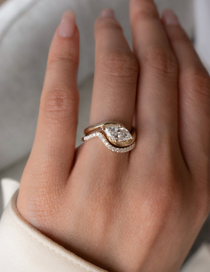 Marquise lab grown diamond swirl bypass bridal set with thin curved pave band on the hand