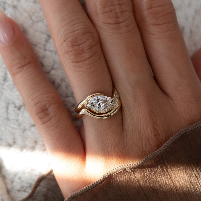 East-west marquise lab grown diamond half pave swirl ring with plain wave band in yellow gold on the hand