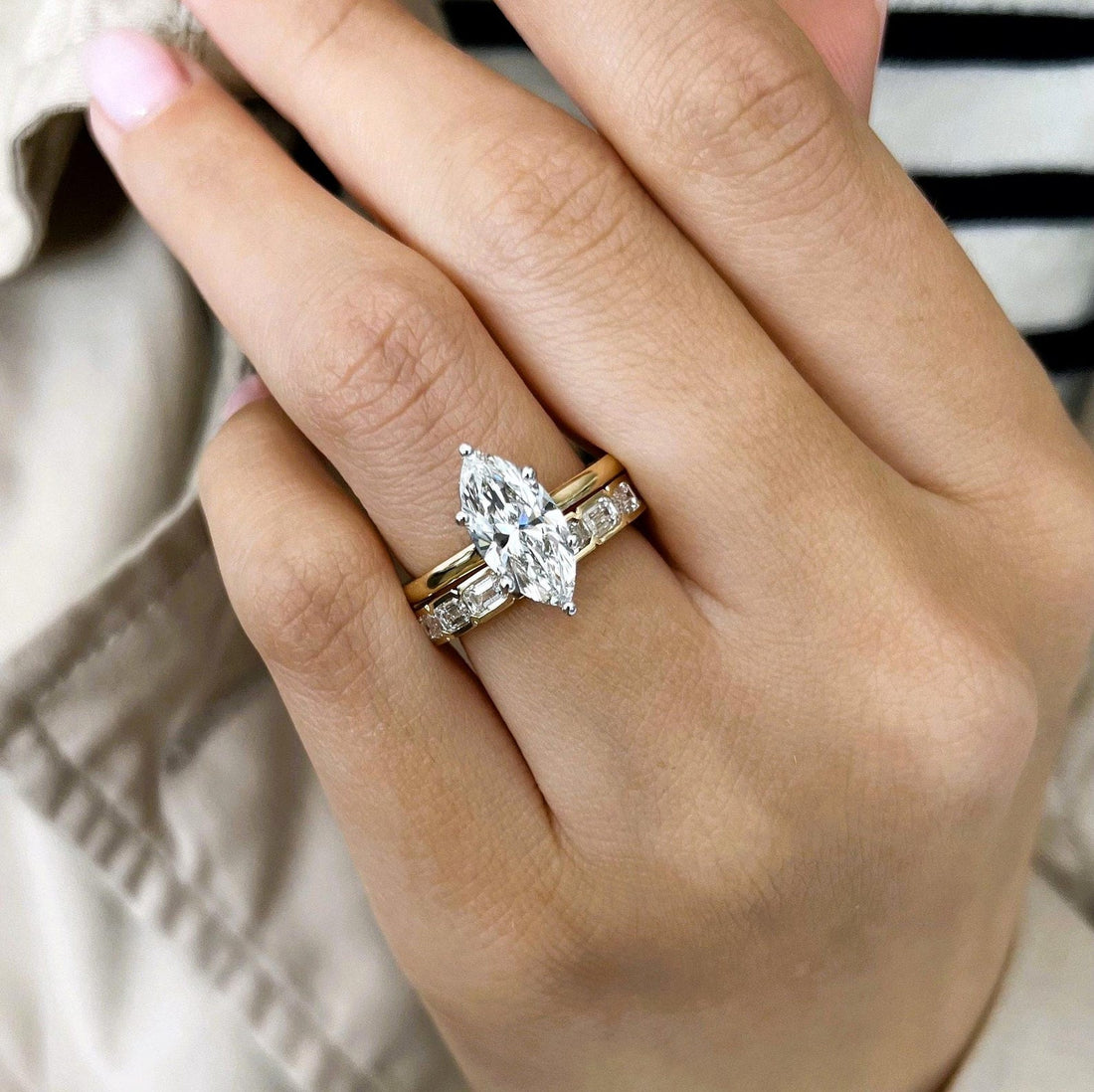 Marquise moissanite hidden halo bridal set with framed emerald-cut band on the hand