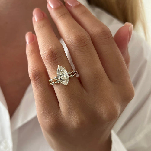 Marquise moissanite bridal set with bezel station bands in yellow gold worn on the hand