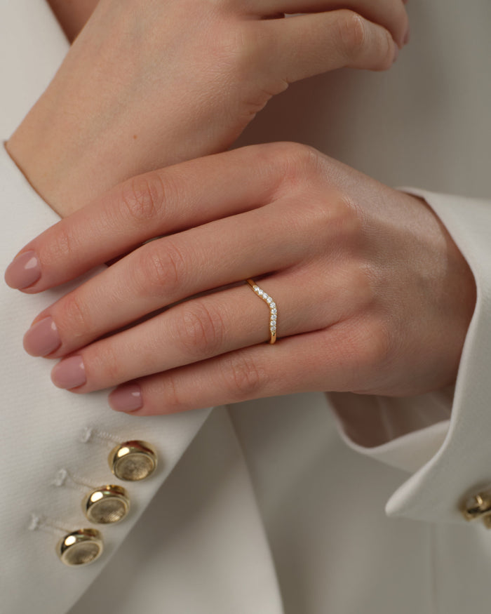 U-curved moissanite wedding band worn on the ring finger