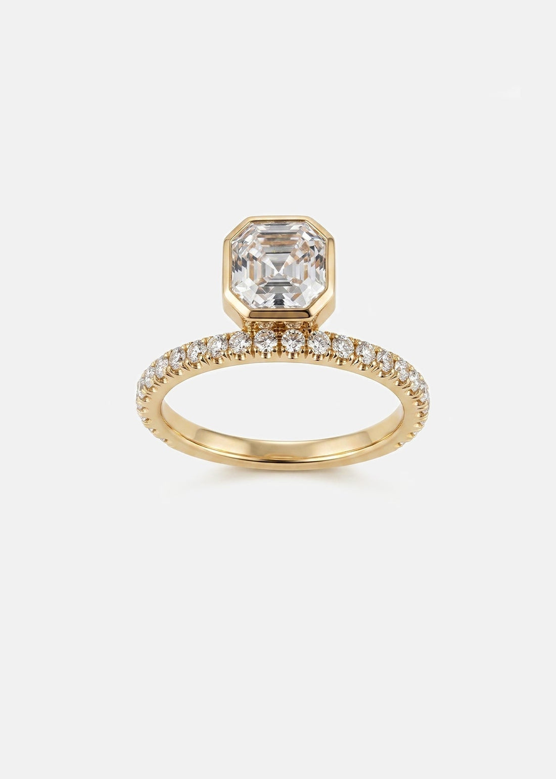 Asscher cut moissanite bezel set engagement ring on a full pave eternity band in yellow gold