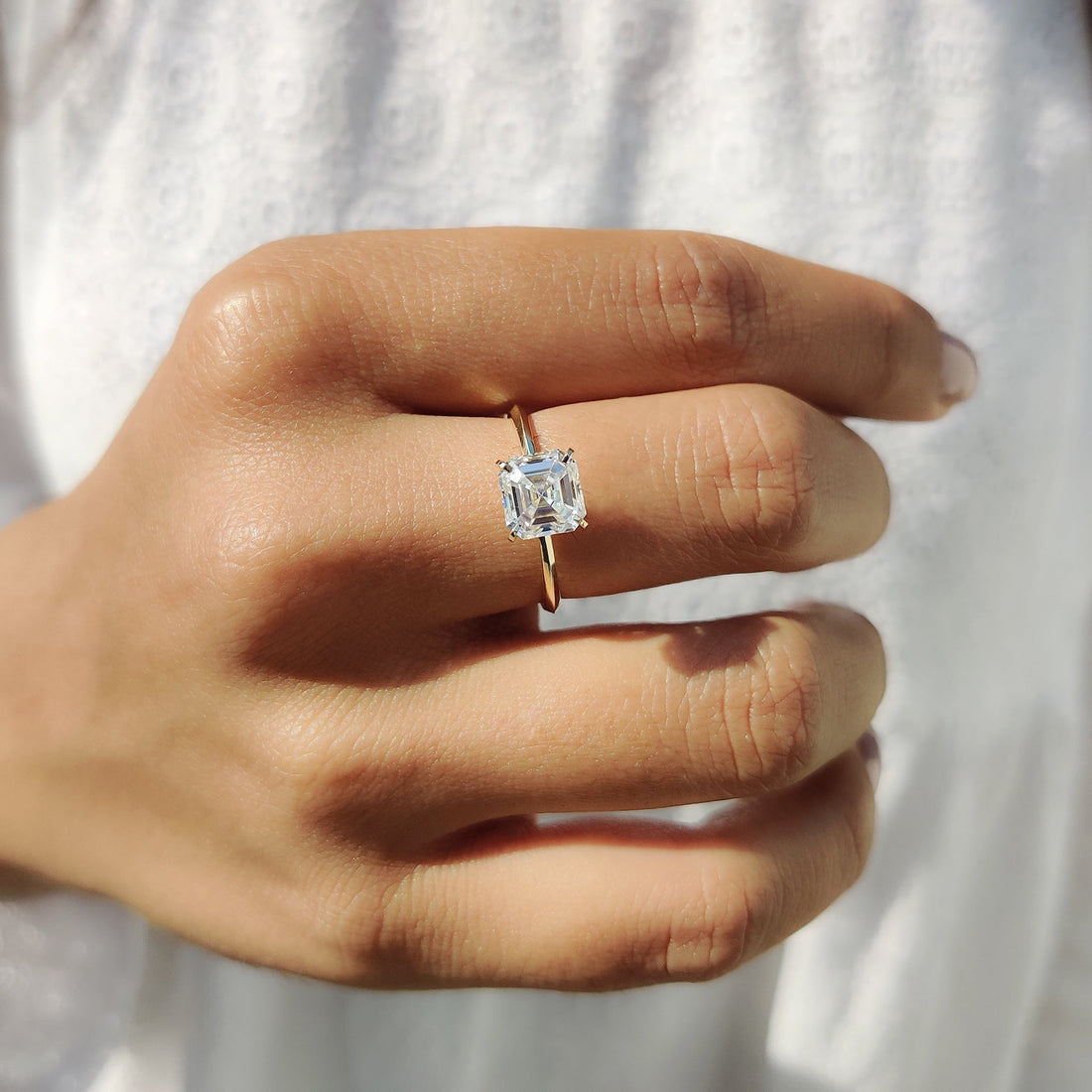 Asscher cut moissanite corner claw solitaire engagement ring on a flat yellow gold band