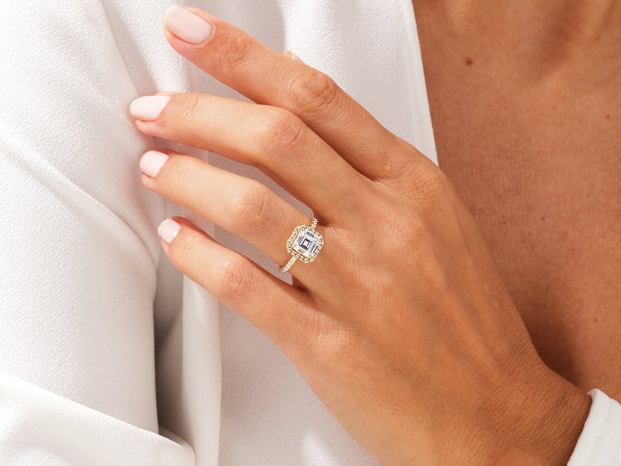 Asscher cut moissanite halo ring with pave band in yellow gold worn on the hand