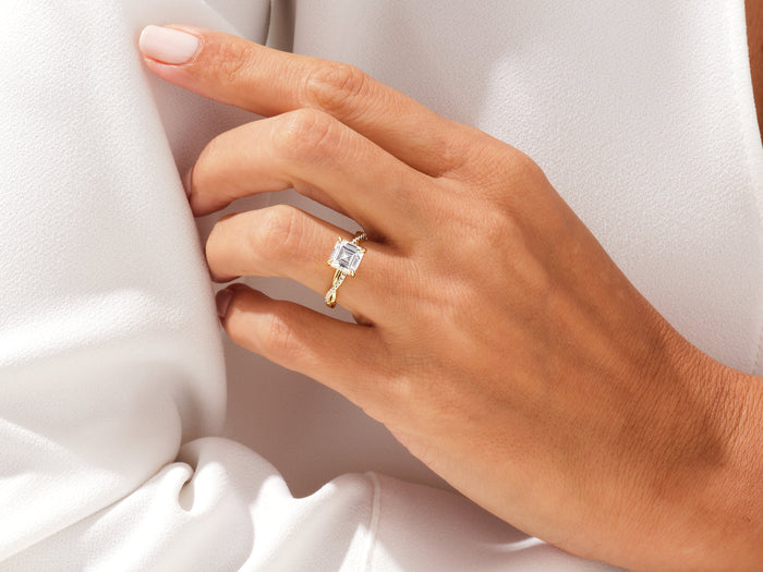 Dainty asscher moissanite twist band ring worn on the hand