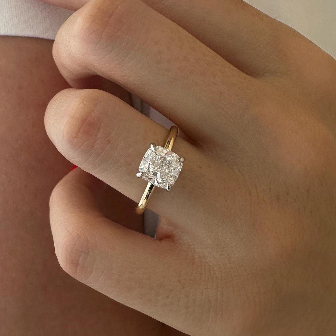 Cushion cut moissanite hidden halo engagement ring in white and yellow gold